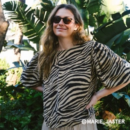 Auf dem Bild steht die Influencerin Marie Jaster vor Palmen. Sie trägt eine Sonnenbrille und eine Bluse mit Zebraprint. Das Bild ist vom Instagram Account von @MARIE_JASTER; Zur abgebildeten Bluse gehen.