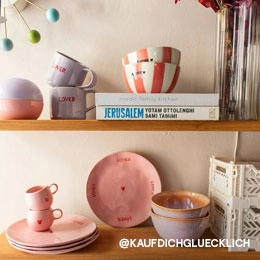 Auf dem Bild sieht mein 2 Regale, die mit rosaner und lilaner Keramik gefüllt sind. Außerdem sind noch Aufbewahrungskisten und Kochbücher zu sehen. Das Bild ist vom Instagram Account von @KAUFDICHGLUECKLICH; Zum abgebildeten Teller gehen.