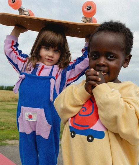 Kind, das Leggings und einen Pullover mit Erdbeeraufdruck trägt; zu KDG Kids gehen